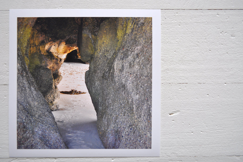 Pinch River unframed 17cm x 17cm Photographic Print on Paper Titled: Caves Beach #2. The subject of the print is looking through a cave opening with the sun reflecting on the cave wall. Top view.