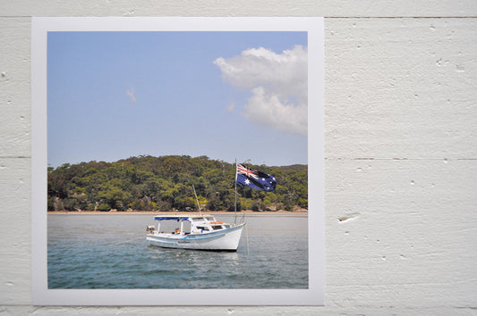 Pinch River unframed 17cm x 17cm Photographic Print on Paper Titled: Spirit of Australia. The subject of the print is a boat on the water flying the Australian flag. Top view.