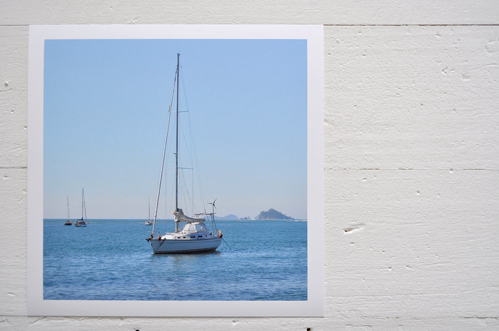 Pinch River unframed 17cm x 17cm Photographic Print on Paper Titled: Sail Away with Me. The subject of the print is a sailboat on the ocean. Top view.