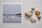 Photographic Print on Paper Titled: Tranquil Waters. The subject of the print is boats docked at a marina and reflections on the still lake water. Top view with love heart shaped stones to style the product image.