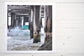 Pinch River unframed 17cm x 17cm Photographic Print on Paper Titled: Underneath the Jetty #3. The subject of the print is a close-up of the iconic Catherine Hill Bay Jetty from underneath, with the weather-worn timber pilings, waves crashing and beautiful aqua blue of the water in the background. Top view.