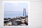Pinch River unframed 17cm x 17cm Photographic Print on Paper Titled: Reids Reserve #2. The subject of the print is a coastal rocky outcrop looking out over the ocean, with mooring posts in the background. Top view.