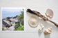 Pinch River unframed 17cm x 17cm Photographic Print on Paper Titled: Reids Reserve #3. The subject of the print is a coastal rocky outcrop looking out over the ocean. Top view with sea shells and driftwood next to it to style the product image.