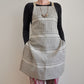 Model wearing Pinch River bib apron / full apron in Corduroy Pathway print against a plain background. Front View.