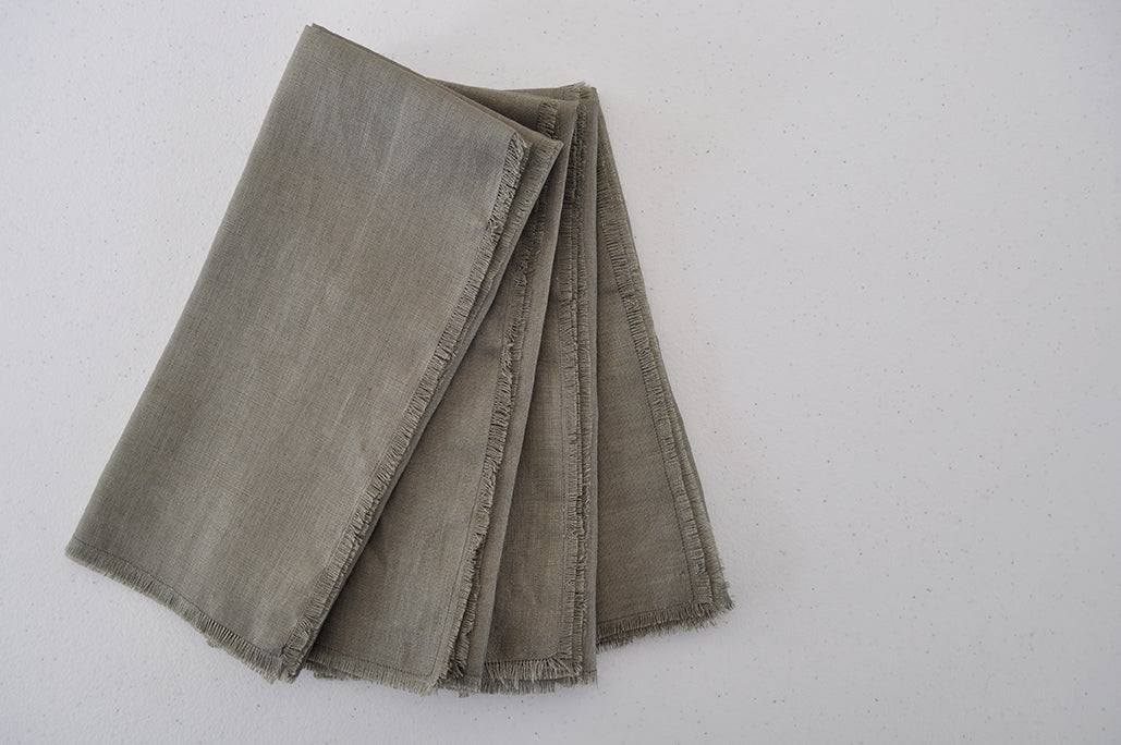 Set of 4 folded Pinch River pure linen napkins in Olive. Top view.