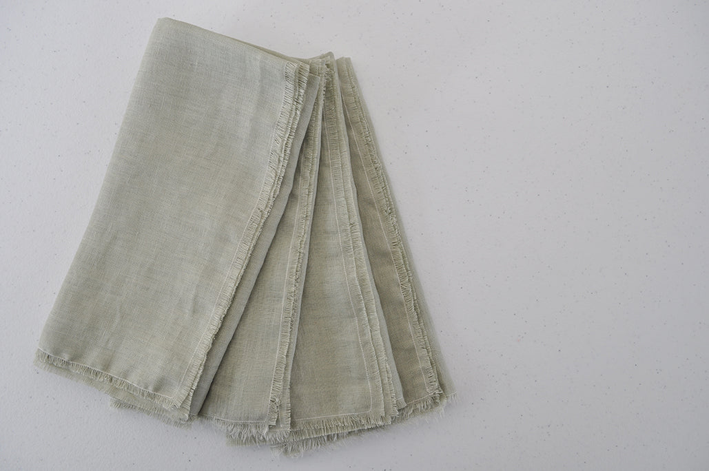 Set of 4 folded Pinch River pure linen napkins in Sage. Top view.