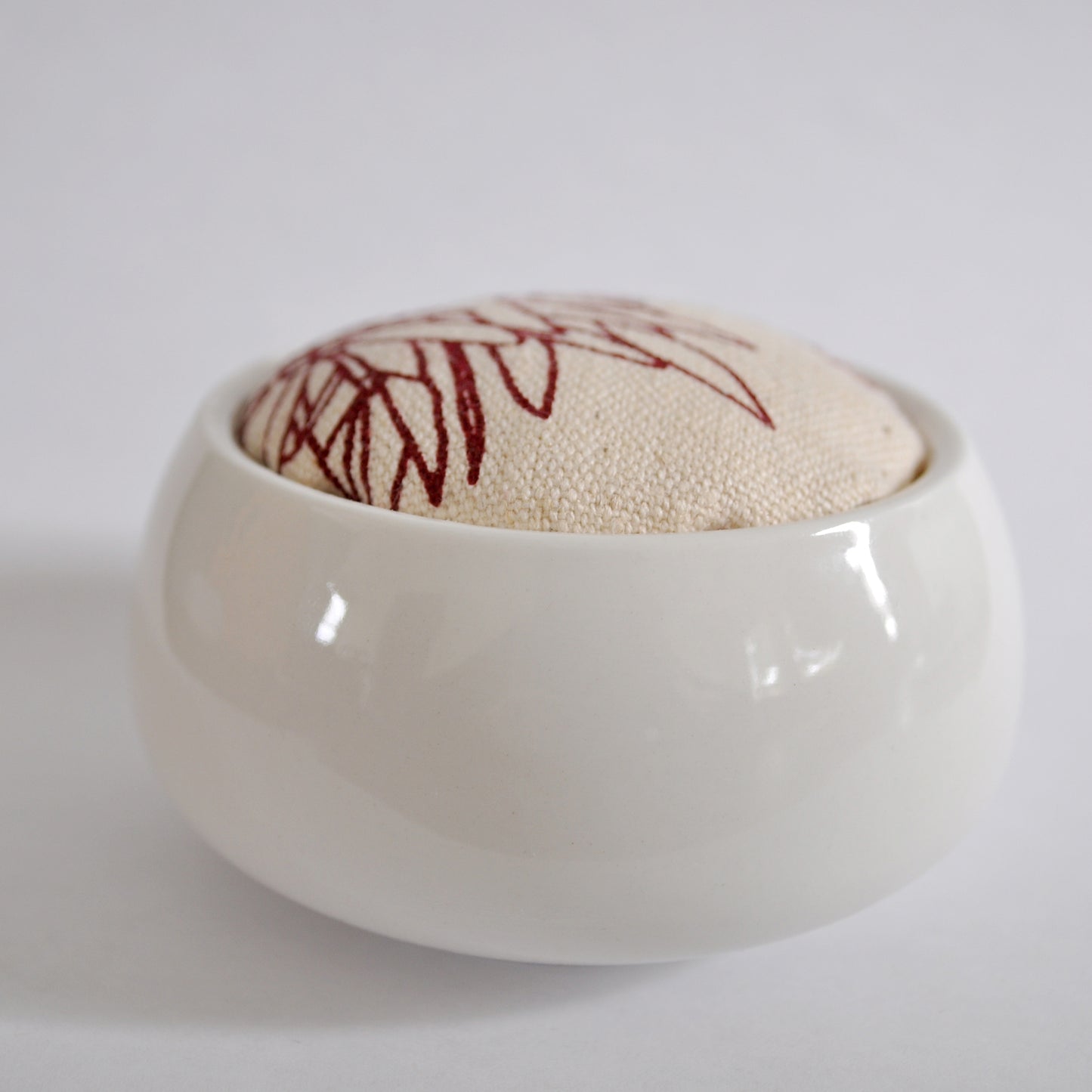 Pinch River ceramic pin cushion featuring Bottle Brush print in Wine Berry (colourway 2). Side view.