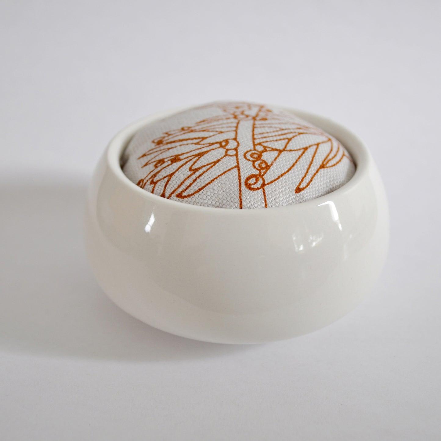 Pinch River ceramic pin cushion featuring Bottle Brush print in Burnt Orange (colourway 2). Side view.