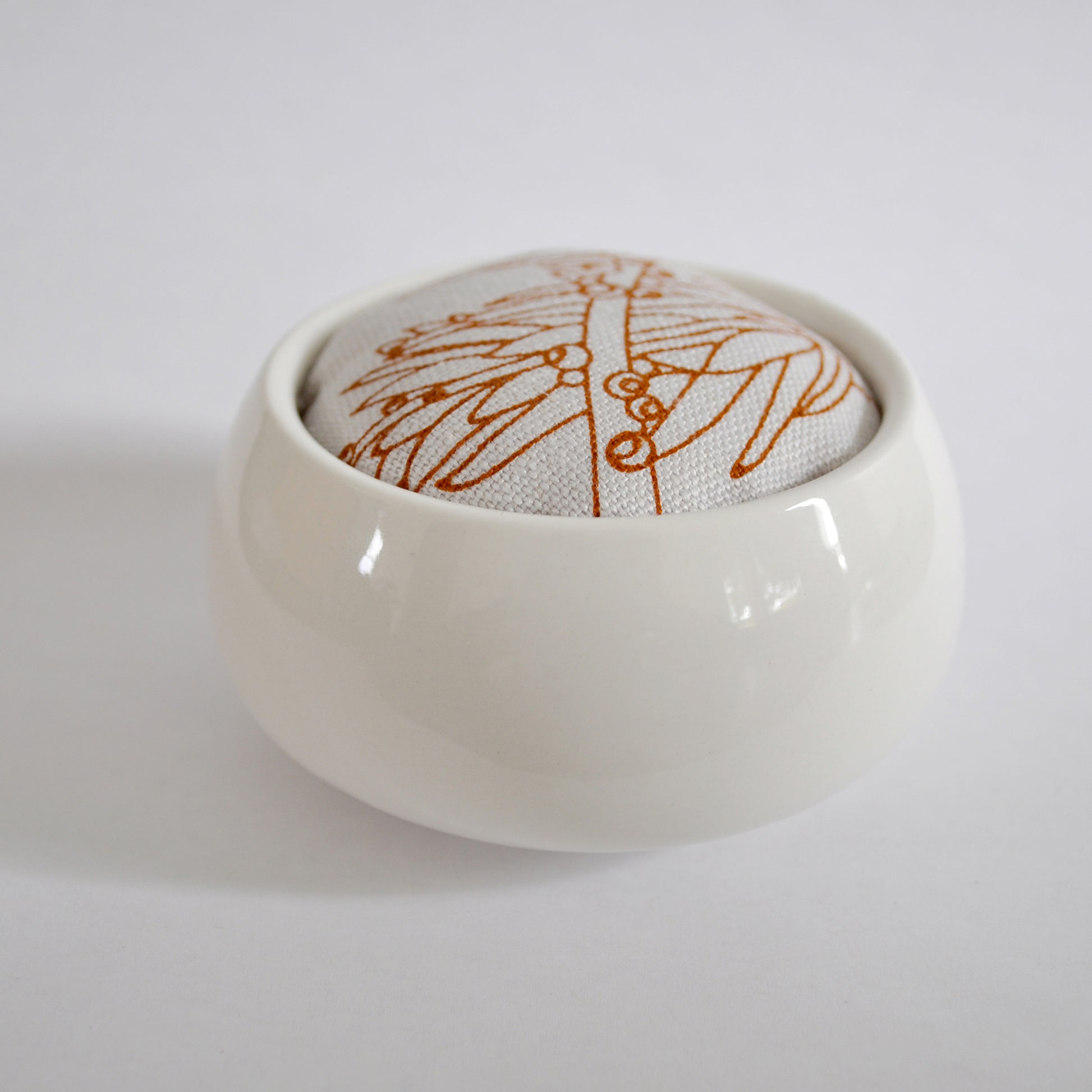 Pinch River ceramic pin cushion featuring Bottle Brush print in Burnt Orange (colourway 2). Side view.
