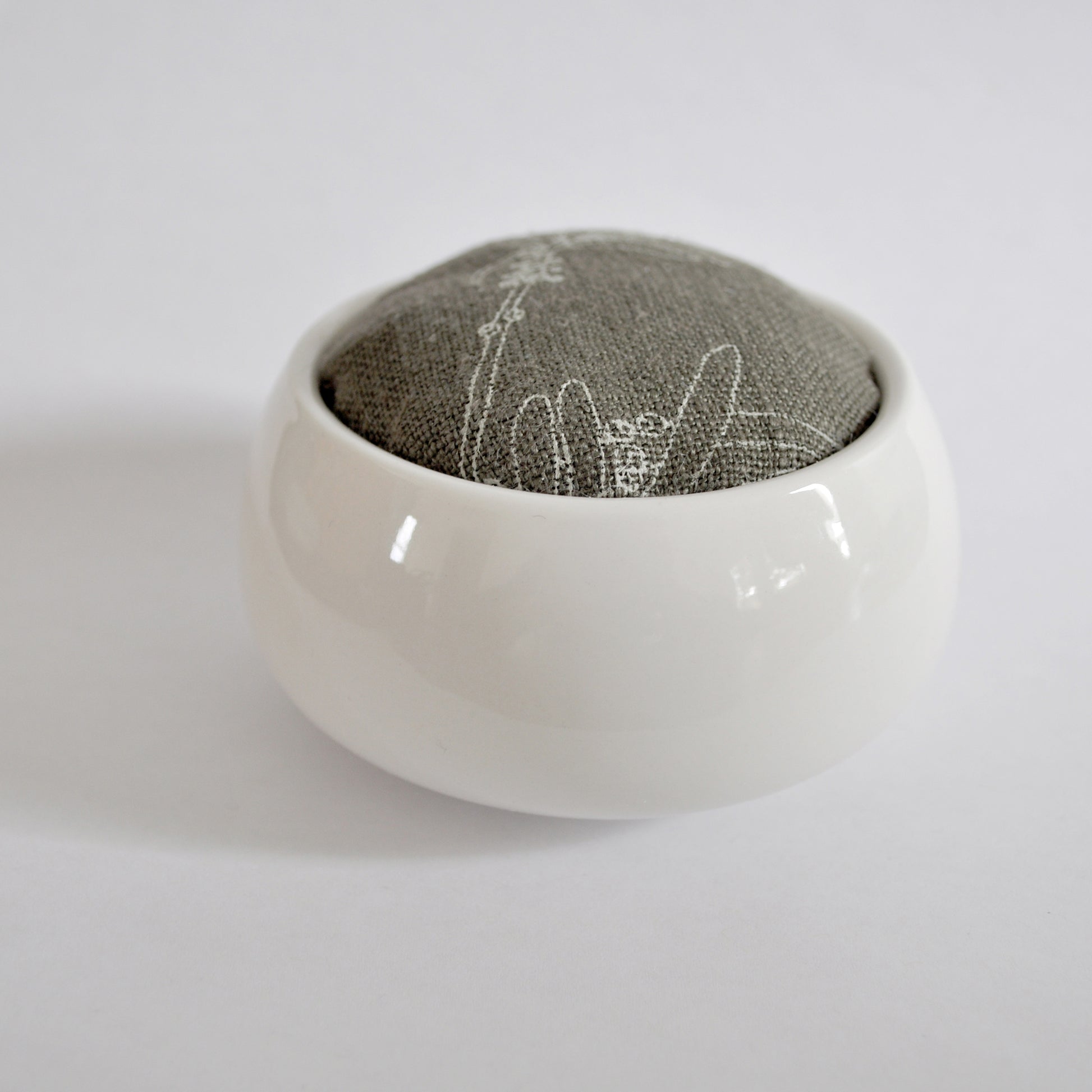 Pinch River ceramic pin cushion featuring Bottle Brush print in Moss Green (colourway 3). Side view.