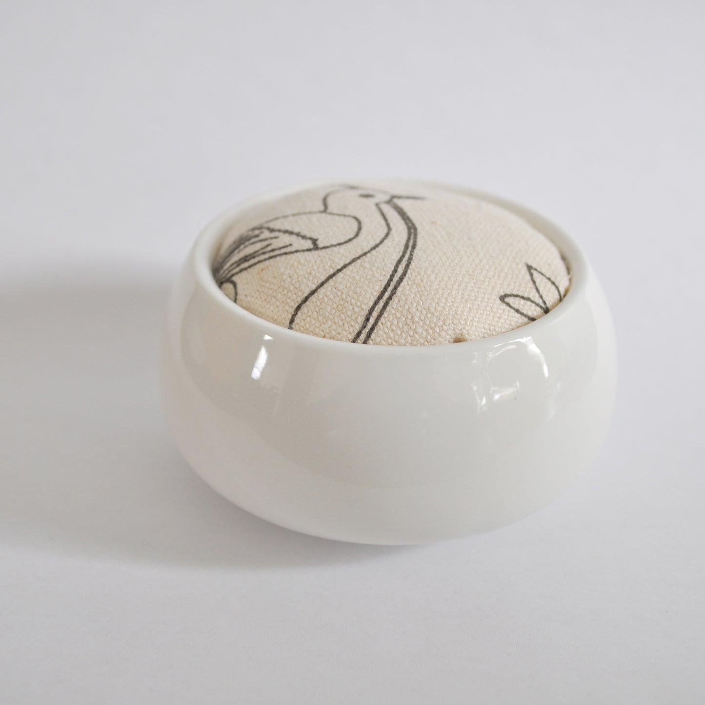 Pinch River ceramic pin cushion featuring Lyrebird print in Grey Bark (colourway 1). Side view.