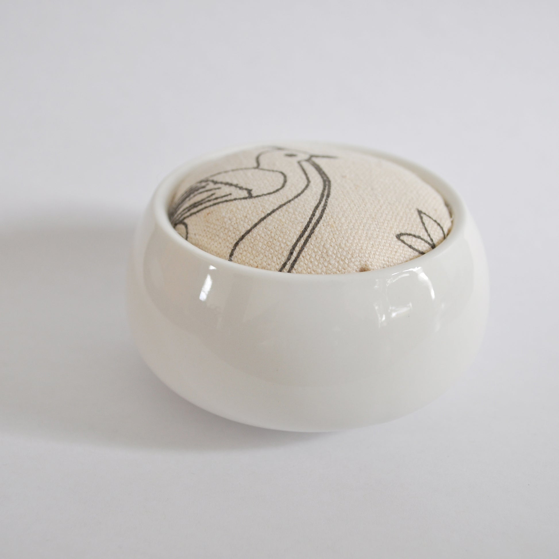 Pinch River ceramic pin cushion featuring Lyrebird print in Grey Bark (colourway 1). Side view.