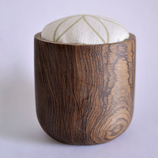 Pinch River teak pin cushion featuring Flower of Life print in Spring Green (colourway 1). Side view.