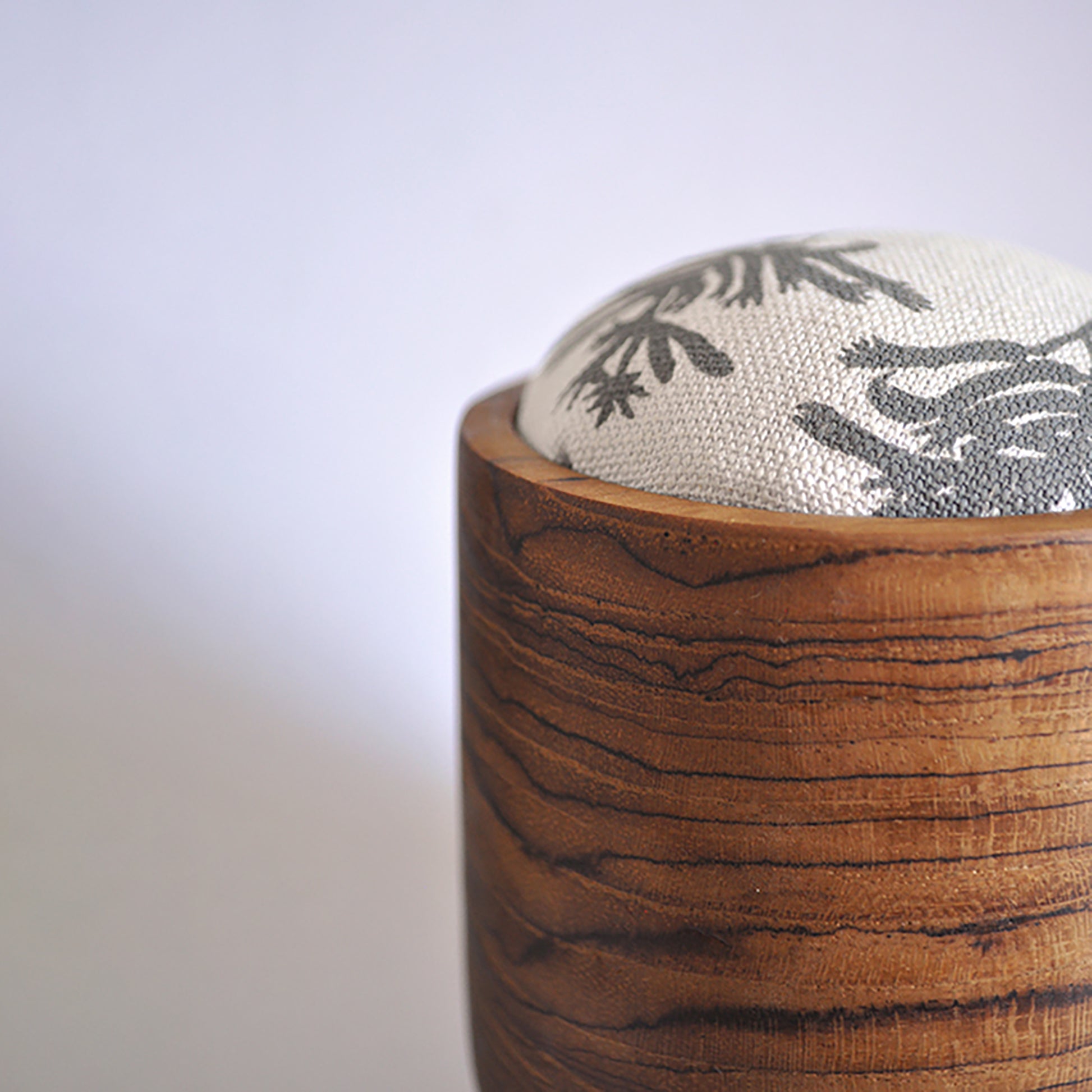 Pinch River teak pin cushion featuring Kangaroo Paw print in Tempest (colourway 3). Close-up side view.