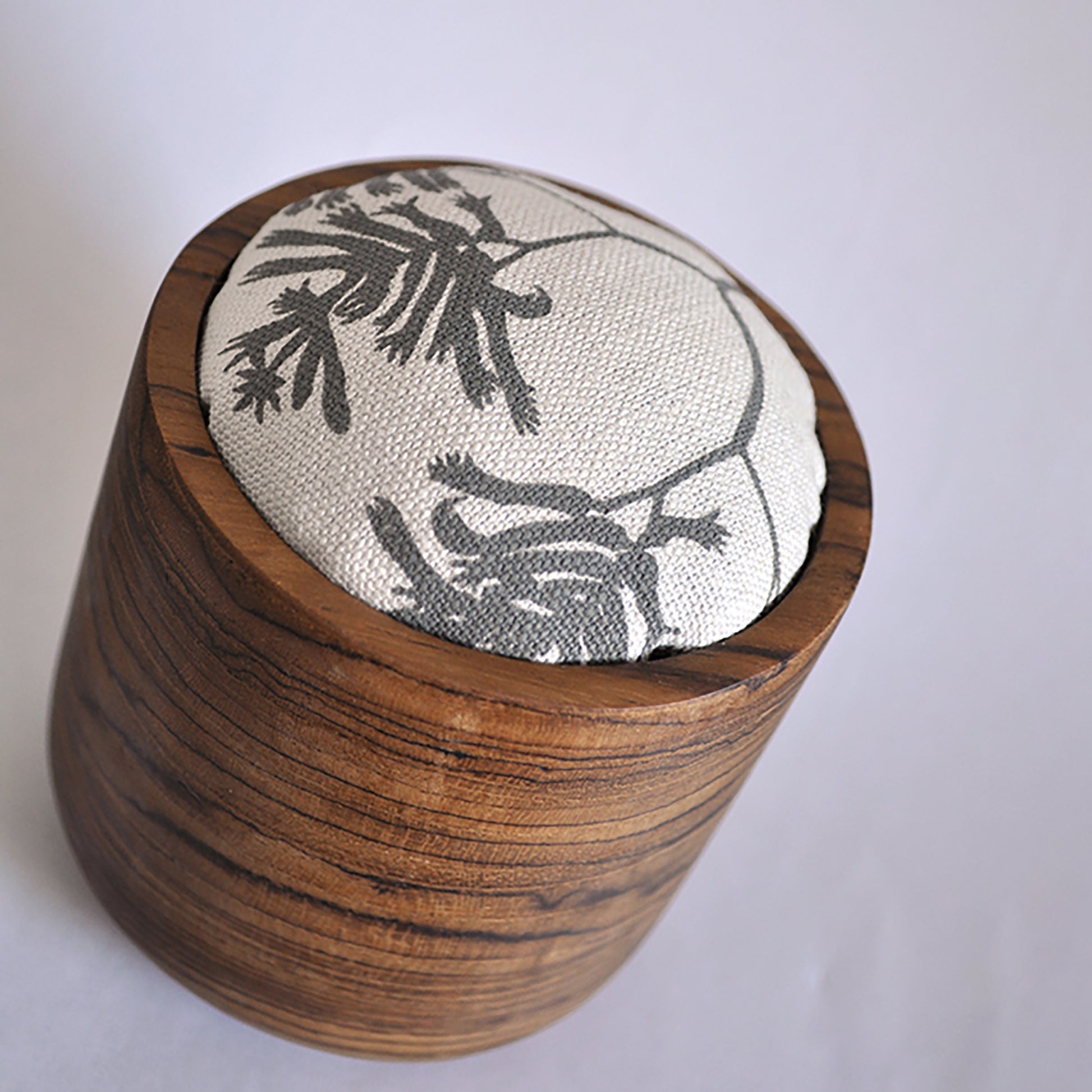 Pinch River teak pin cushion featuring Kangaroo Paw print in Tempest (colourway 3). Angled view.
