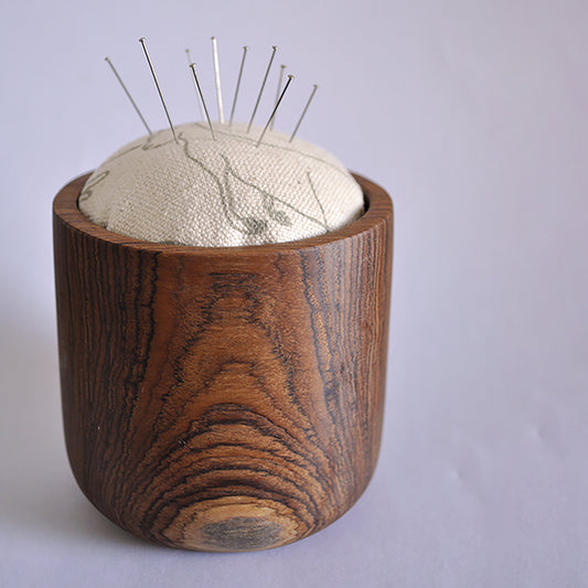 Pinch River teak pin cushion featuring Kangaroos print in Moss Green (colourway 2). Side view. Product image is styled with pins.