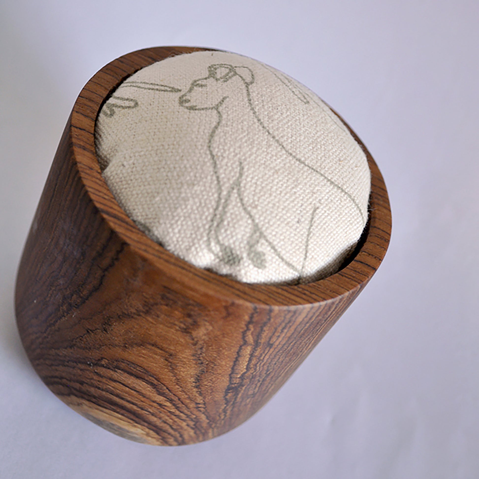 Pinch River teak pin cushion featuring Kangaroos print in Moss Green (colourway 2). Angled view.