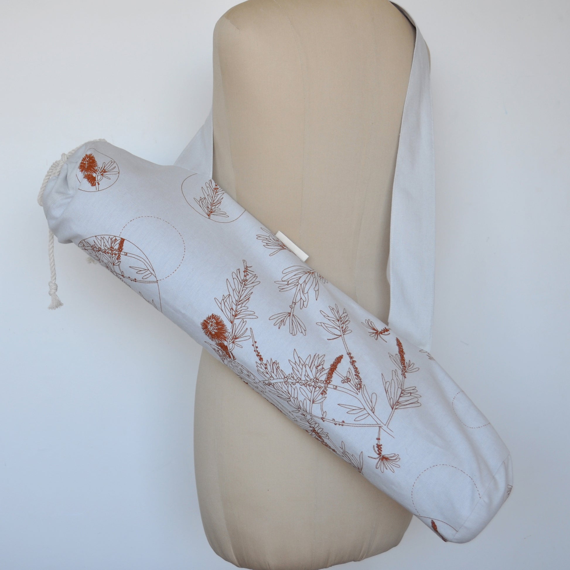 Pinch River yoga mat bag in Wattle Bird in the Bottle Brush print in Burnt Orange on Silver Ash (colourway 2), on dressmakers dummy. Full view.