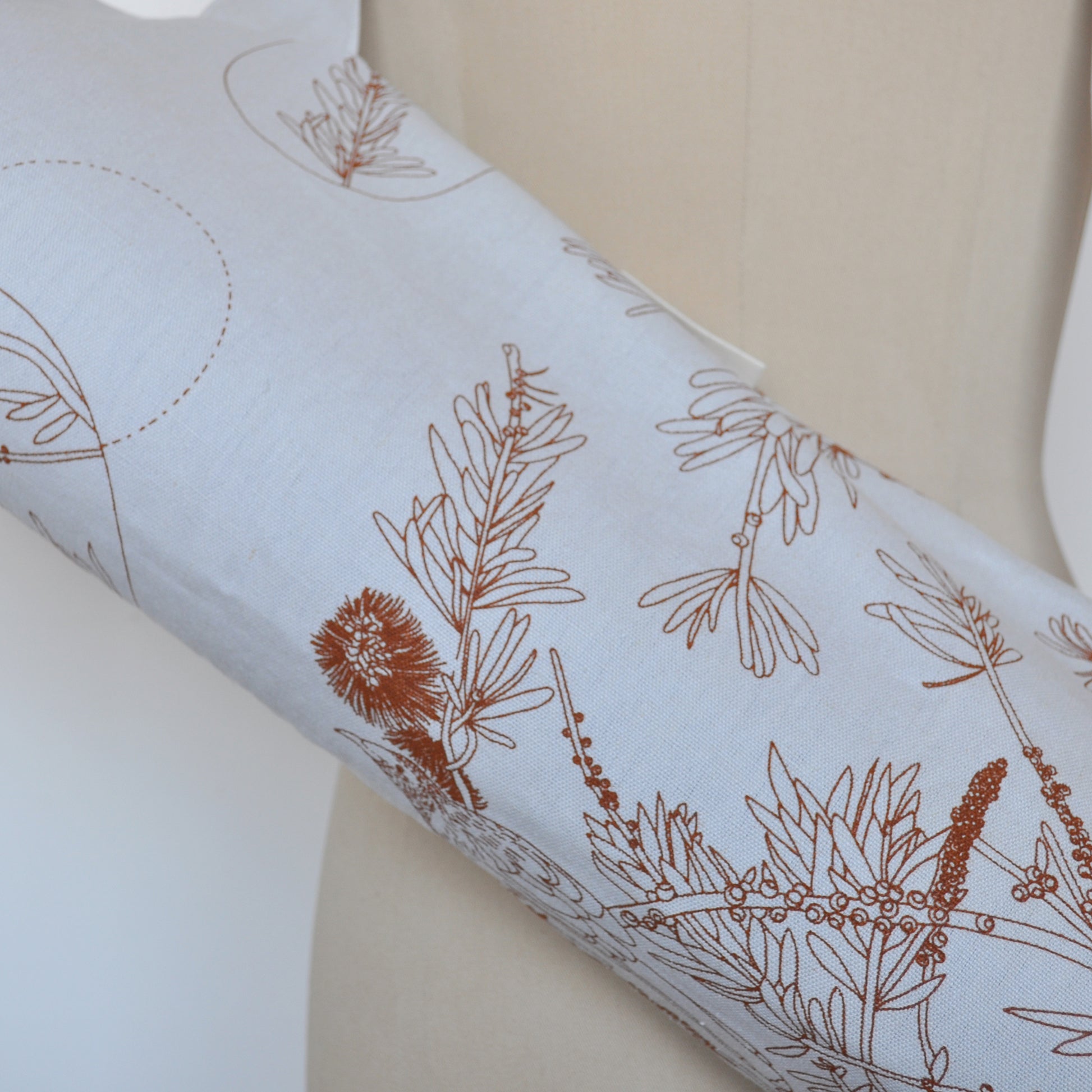 Pinch River yoga mat bag in Wattle Bird in the Bottle Brush print in Burnt Orange on Silver Ash (colourway 2), on dressmakers dummy. Close-up view.