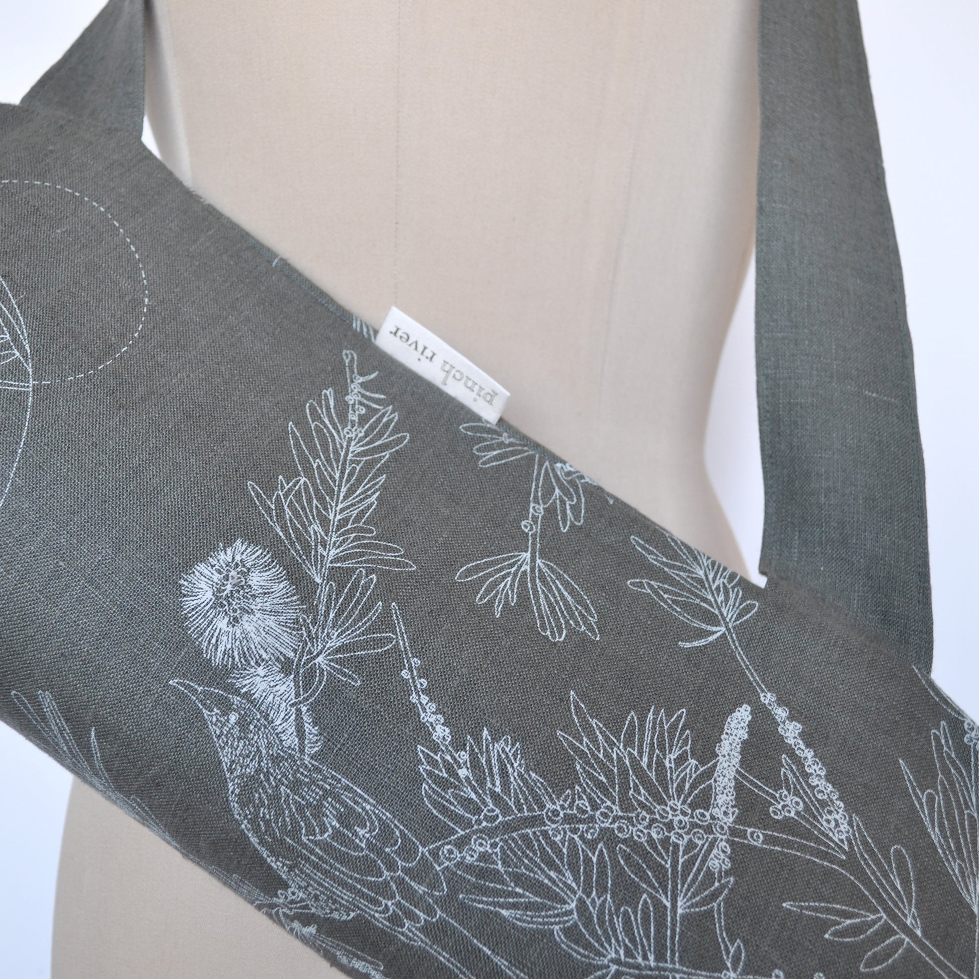 Pinch River yoga mat bag in Wattle Bird in the Bottle Brush print in Moss Green on Forest Green Linen (colourway 3), on dressmakers dummy. Close-up view.