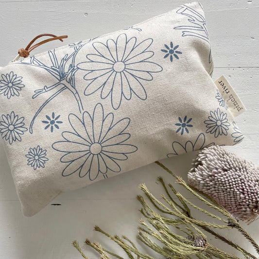 Pinch River zipper pouch featuring Brachycomb print in Horizon Blue (colourway 1). Top view. Product image is styled with Australian native flora.