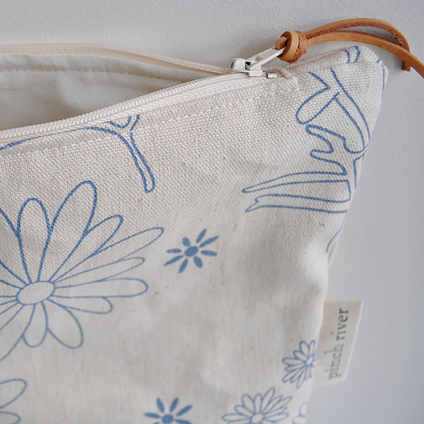 Pinch River zipper pouch featuring Brachycomb print in Horizon Blue (colourway 1). Side view with zipper opened to show the pouch is fully lined.