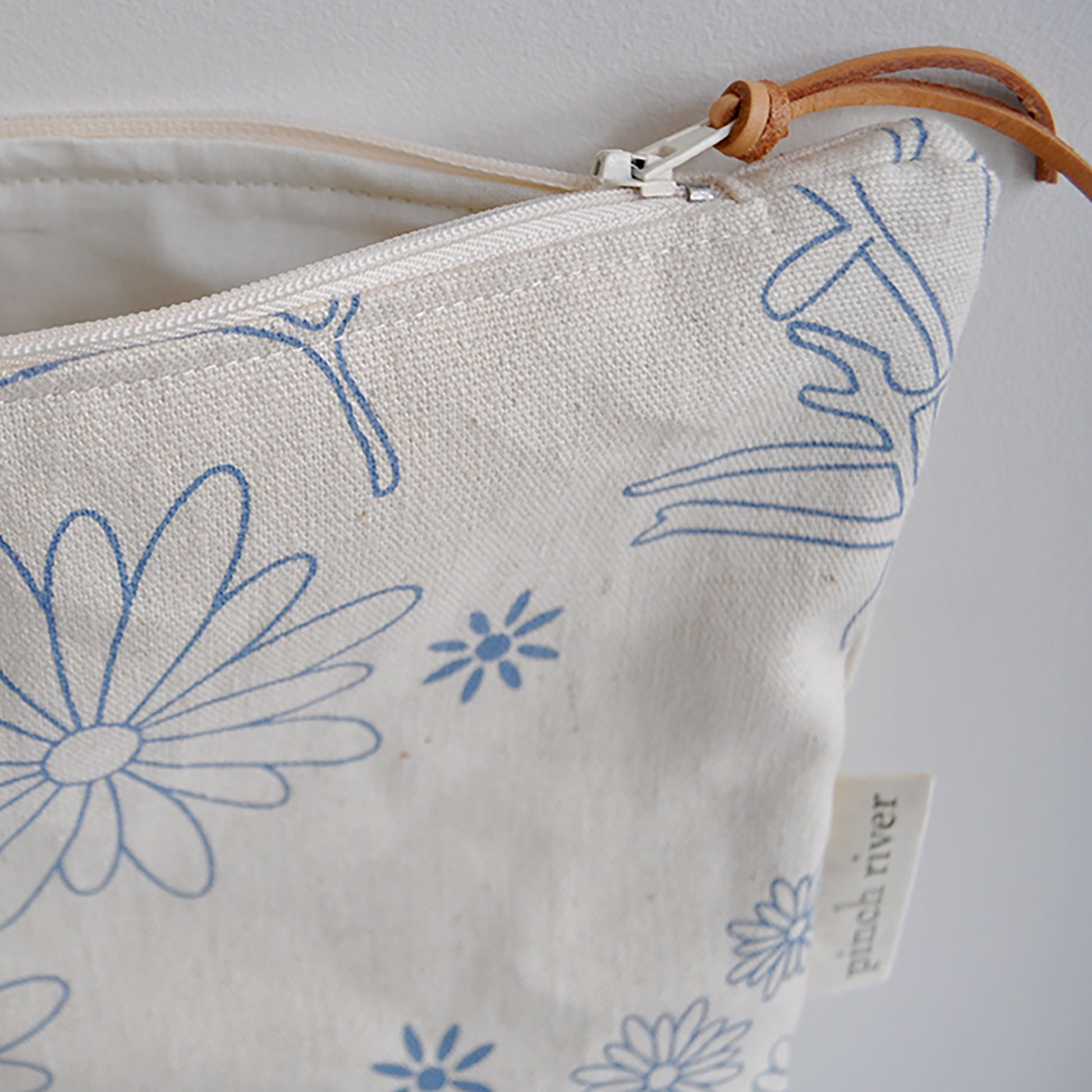 Pinch River zipper pouch featuring Brachycomb print in Horizon Blue (colourway 1). Side view with zipper opened to show the pouch is fully lined.