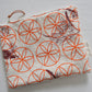 Pinch River zipper pouch featuring Wattle Bird in the Bottle Brush print in Wine Berry (colourway 1) overprinted with Flower of Life print in Fiery Orange (colourway 3). Top view.