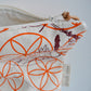 Pinch River zipper pouch featuring Wattle Bird in the Bottle Brush print in Wine Berry (colourway 1) overprinted with Flower of Life print in Fiery Orange (colourway 3). Side view with zipper opened to show the pouch is fully lined.