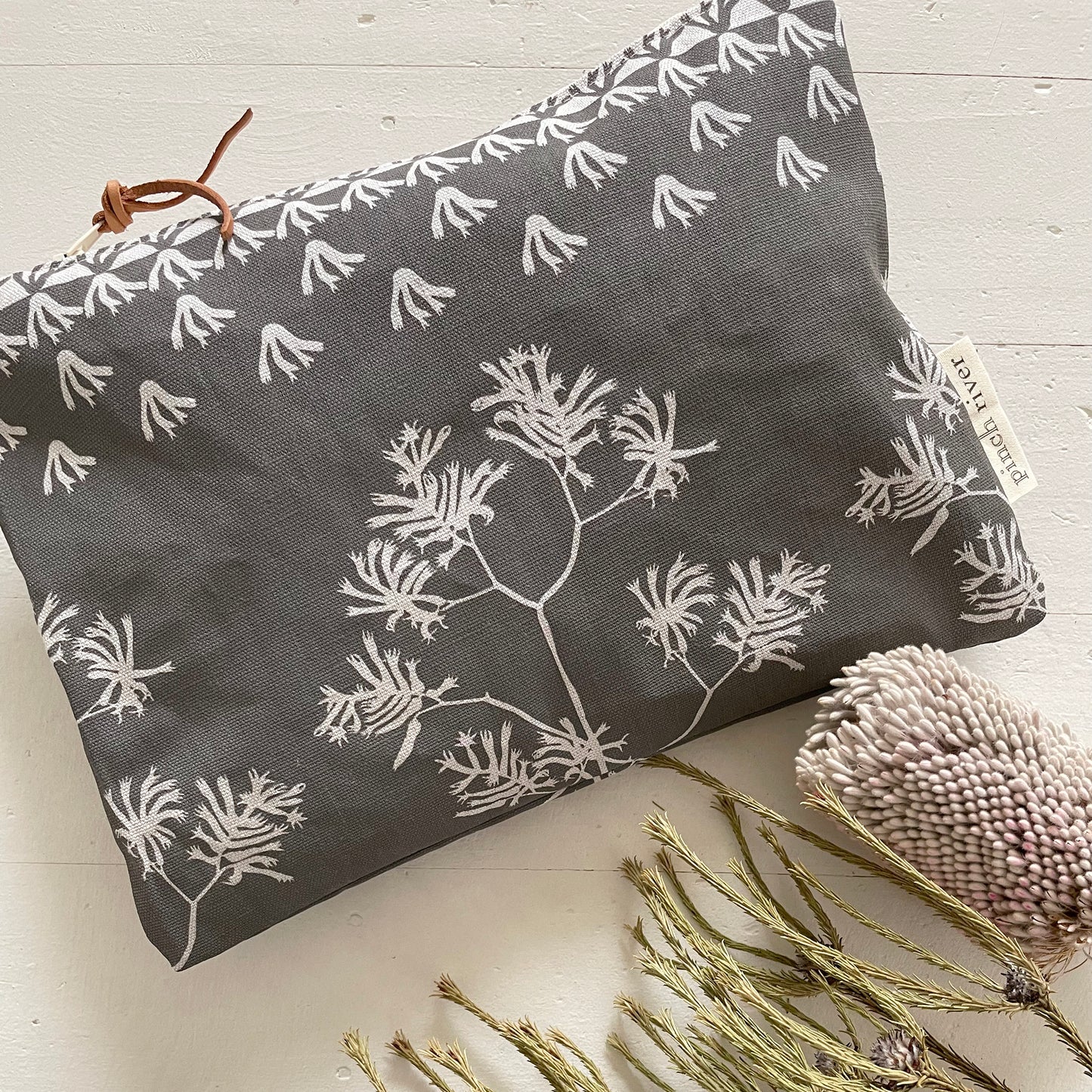 Pinch River zipper pouch featuring Kangaroo Paw print in Tempest (colourway 3_v2). Top view. Product image is styled with Australian native flora.