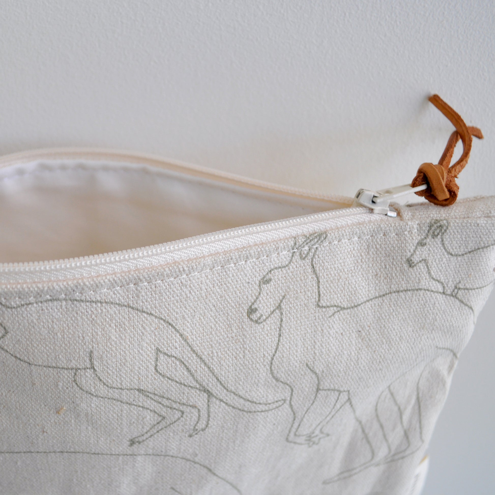 Pinch River zipper pouch featuring Kangaroos print in Moss Green (colourway 2). Side view with zipper opened to show the pouch is fully lined.