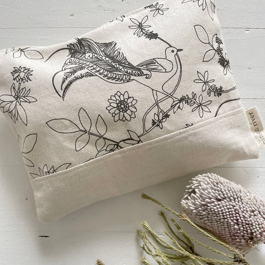 Pinch River zipper pouch featuring Lyrebird print in Gey Bark (colourway 1). Top view. Product image is styled with Australian native flora.