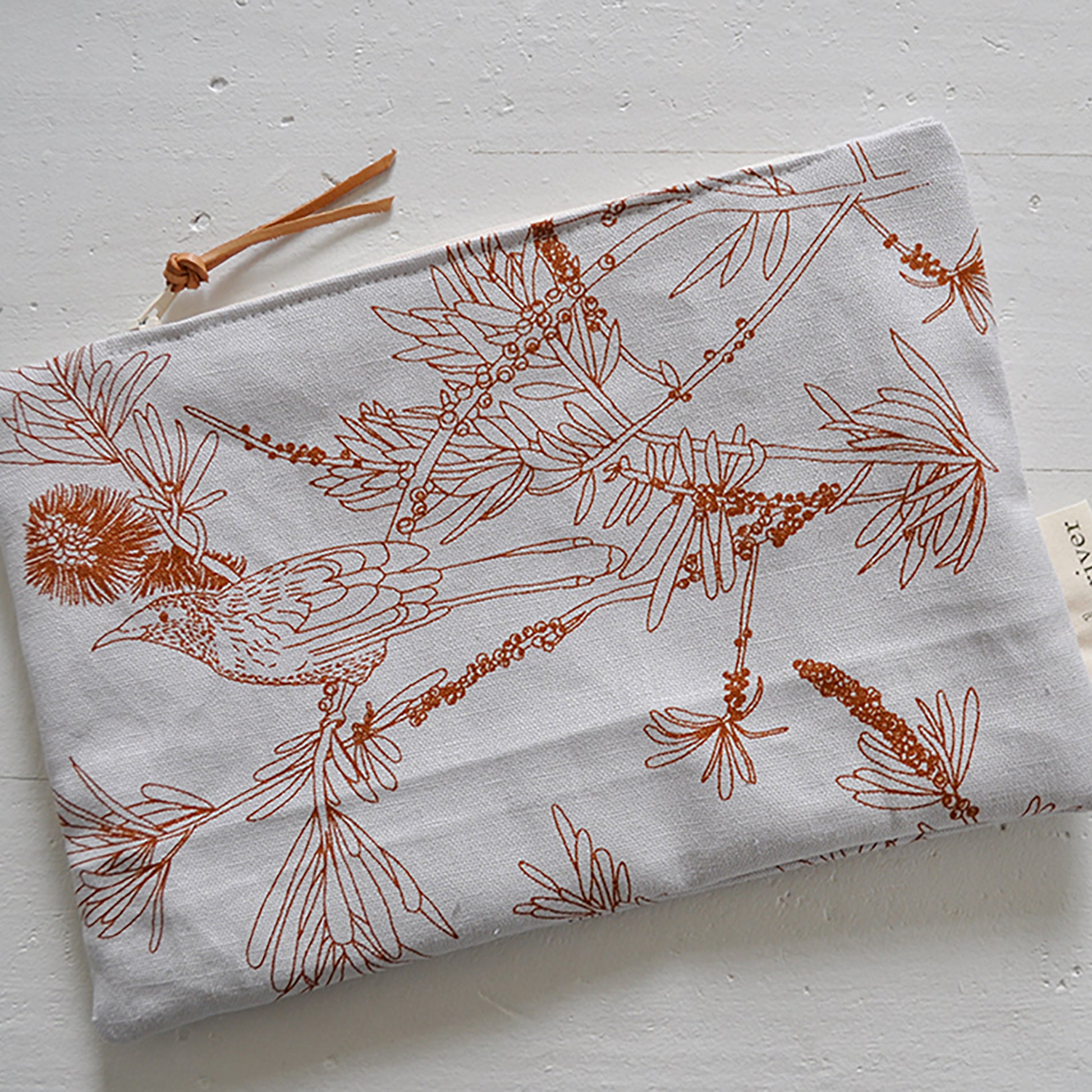 Pinch River zipper pouch featuring Wattle Bird print in Burnt Orange (colourway 2). Top view. 