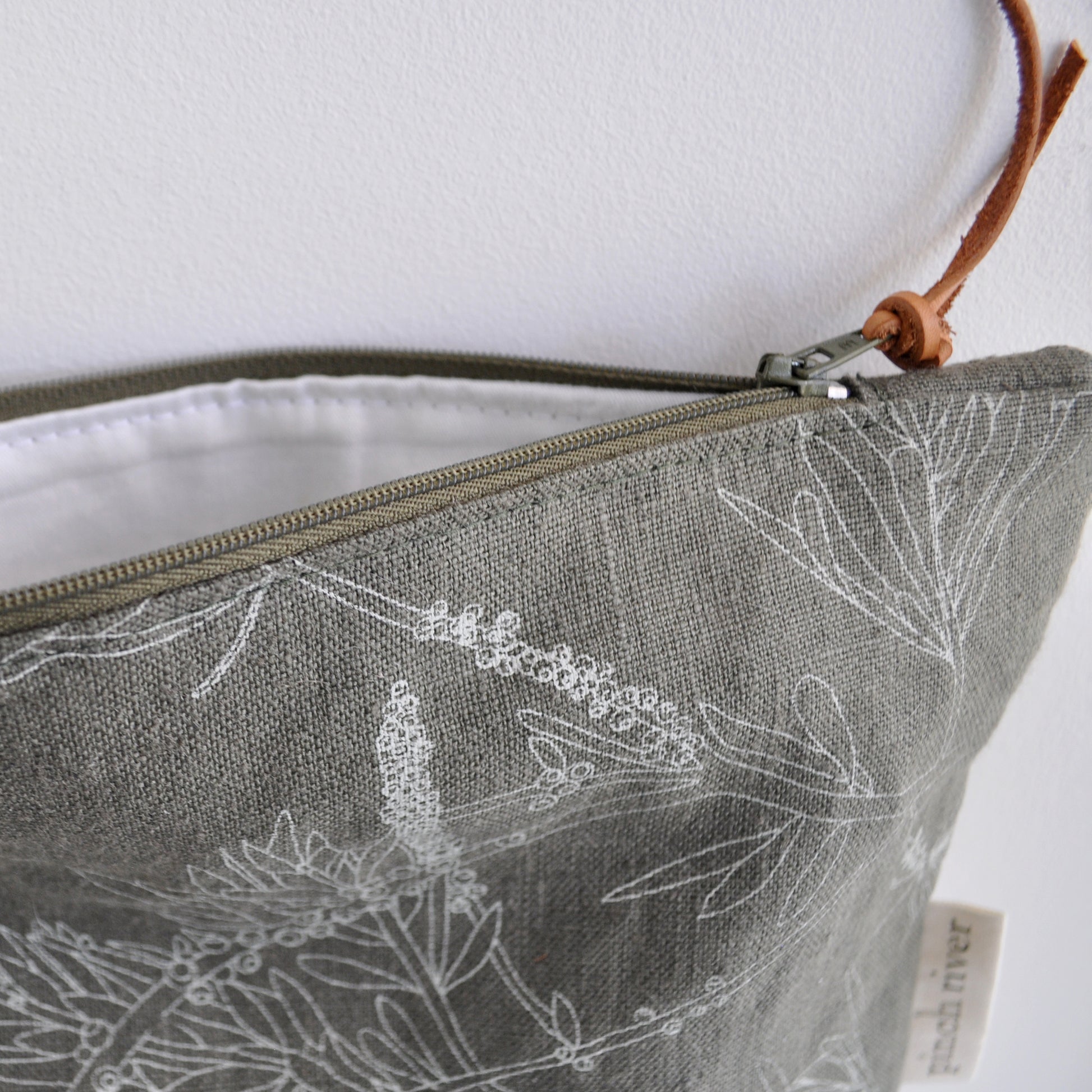 Pinch River zipper pouch featuring Wattle Bird print in Moss Green (colourway 3). Side view with zipper opened to show the pouch is fully lined.
